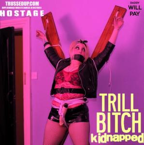 www.trussedup.com - trashy goth girl  PVC mini hostage tied up gagged st Andrews cross bondage thumbnail